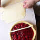 Lay the first strip directly across the pie, close to the center.