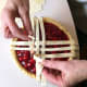 Here, I am showing how I weave the strips by lifting up ones that are already laid on the pie filling. This means that I need to be very careful and not get too much filling on my fingers or the strips.