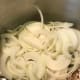 Add the sliced onions to the same pot in which you cooked the bacon. Toss in the pepper, red pepper flakes and cayenne and allow to cook until softened, about ten minutes.