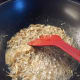 Fry the anchovies in a wok until crispy and brown.