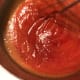 Stir in two cans of tomato sauce, whisk well and bring up to a simmer.