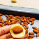 Use your hands to roll the dough into many small balls. Make an indentation to place an almond in the center.