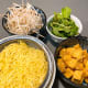 Before assembling, gather the noodles, fried tofu, bean sprouts, and mint leaves on the table.