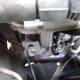 J. Loosen the alternator locking bolt (left), then turn the alternator belt adjustment bolt (right) counter-clockwise to relieve tension on the belt.