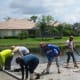 Here the workers are leveling the concrete as it was being pumped into the area. The edges were previously defined with boards and stakes to contain the concrete. The proper slope was determined at that time.