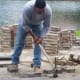 As you can see, he's using a mattock which worked well for bringing up the pavers.