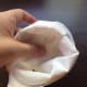 Step 5. Fold the undersides of the toilet paper in towards the center (like closing the ends of a gift wrap). Start on one side and work your way around.