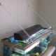 A cheap Menards wire shelf with an added nylon string to keep it in place.