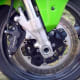 Location of the brake caliper; on the rear side of the front wheel.