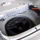 The plastic storage bin removed, exposing the spare tire. The arrow points to the molding to be lifted out.