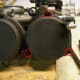 Remove the carburetor top screws (circled in red). Remove the vacuum piston and vacuum piston spring under the carburetor top.