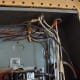 Wires entering the panel through cable clamps.