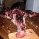 With the carcass belly-down, start at the flank and cut off the legs by following up and over the ball of hip joint, then almost straight back.