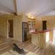 This kitchen demonstrates the heavy emphasis on natural wooden surfaces integrated into the rustic-feeling interior design. Those panels under the dog are under-floor storage.