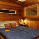 A bedroom space can be simultaneously cozy, enclosed within warm, antique wood, and open with windows to the outside.