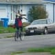 一个骑自行车的人拿着一个吊扇。