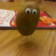 Attach toothpicks to bottom so it can stand up and start arranging the face with peanut butter as the glue.