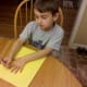 Trace your child's hand on yellow, red, and orange construction paper.
