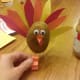Bend orange strips of paper back and forth to create turkey legs. Attach to bottom of potato.