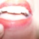 Outline it with darker makeup stick and then add some smudges below the mouth with eye shadow.