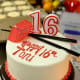 A birthday cake for a teenager decorated in white, red, and black.