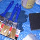 Paintbrushes, sanding block, and gloves.