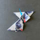 Take two folded tiles and interlock them as shown in photos. Think of one piece in each hand. The point of the piece in the left hand goes under the diamond of the tile in your right hand and meets at the red arrows.