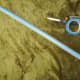The first length of blue tape along the cardboard tube. Fold the tape under at the tip.