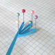 Arrange six pins in a circle and wrap a strip of paper around each pin.
