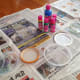 Cover work area with newspaper. Gather 1 small glass jar, and 5 shallow plastic lids to hold the 5 colors of fabric paint.