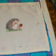 Frame measured and pinned, and the edge of the hedgehog cross stitch protected with a calico binding.