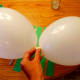 Blow up and tie 2 balloons together.