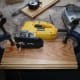 Using the jig saw to cut the wood clamped to the bench to the correct width