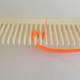 Wrap quilling paper around and under a prong on the left.
