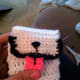Face on cat cozy is flap, tongue acts as a "button" and slides through a loop on the face to fasten cozy.