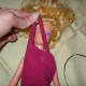 Pull the strap over your doll's head.