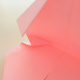 Pinch the tip of one corner and fold it in half to align with the small crease line inside.