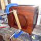 Wooden cat motif clamped in place while the glue dries.