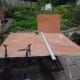 A 4ft x 8ft sheet of 12mm plywood being marked up to cut the sections for the three shelves.