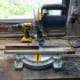 Cutting scrap wood to size for three temporary leg supports while fixing the unit to the wall.