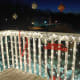 A nicely lit balcony with white light, red ribbon and colored balls