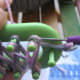 Use hook to lift bottom set of threads over top set on both end pegs. That will secure it so you can let the end go.