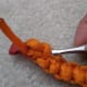 Tuck the ends under the knots on the inner surface of the bracelet