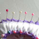 Start wrapping the pins on the side with the purple ribbon