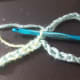 Make a chain with the colours you want, as long as you want your cuff to be. slip stitch first colour through first loop and make a chain long enough to go around your wrist.