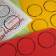 Draw circles on the plastic sheets and thick paper.