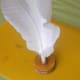 Put a generous amount of glue in the hole and insert the bunch of feathers into the hole of the stack. Let the glue dry thoroughly.