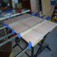 Clamping the doweled panel together (keeping it flat) until the glue dries.