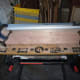 Clamping the dowelling jig into place on the edge of the plank