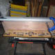 Repositioning the jig at the other end of the plank to complete drilling the holes